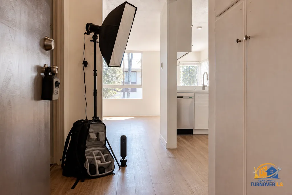 Gear staged outside a Westwood apartment door with a lockbox, ready for a turnover photography session in Los Angeles