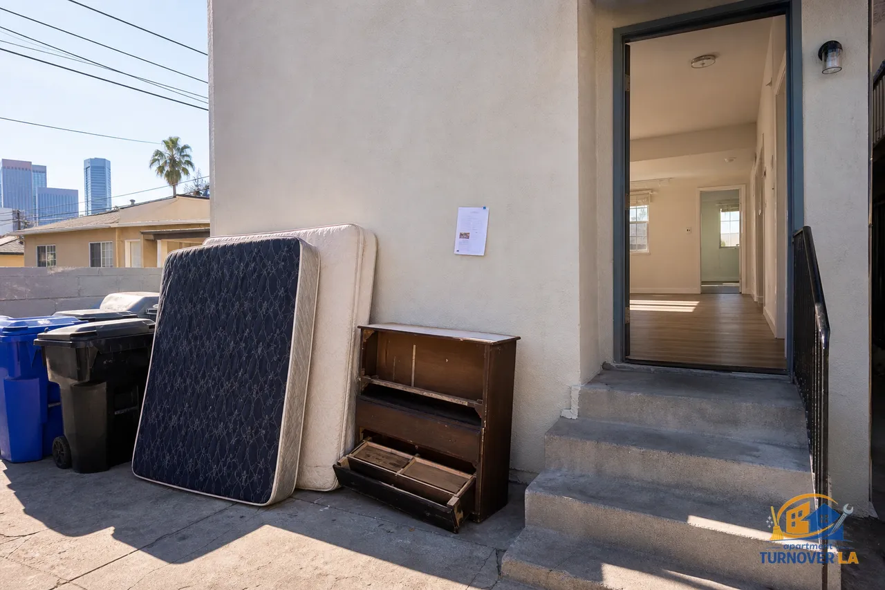 Koreatown alley staging for Los Angeles Sanitation bulky item pickup beside city bins after an apartment turnover